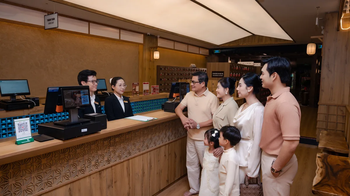 Khách trao đổi tại quầy check-in trước khi đặt trải nghiệm