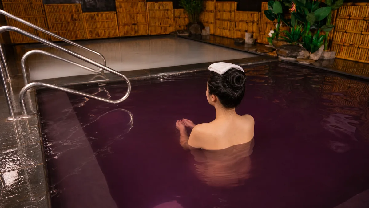 Khách búi tóc và giữ khăn khô khi ngâm bể Onsen tại AMARE