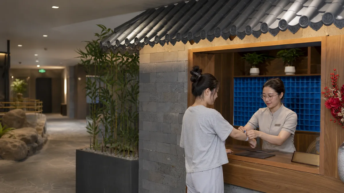 Khách mới nhận vòng tay và hướng dẫn tại quầy check-in AMARE