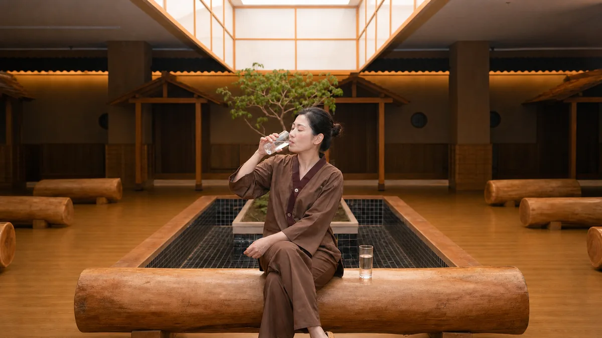 Khách uống nước sau khi trải nghiệm Onsen và Sauna tại AMARE